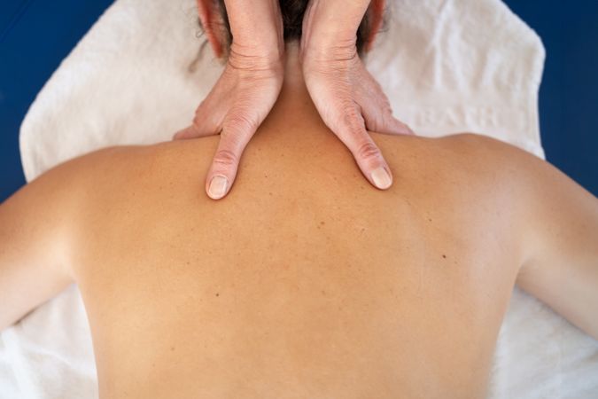 Hands of physical therapist working on client's neck