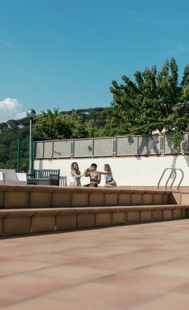Group of friends sunbathing by the pool