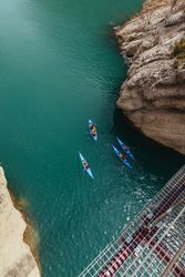 People crossing a river by kayak