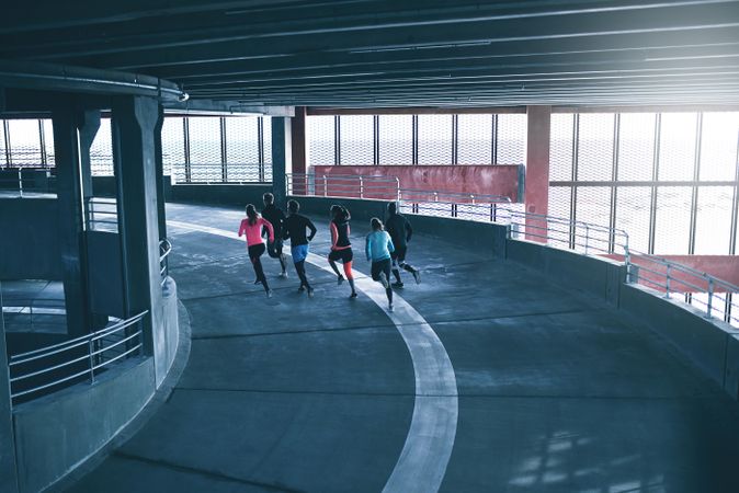 Shot looking down of people running around a bend in the concrete track