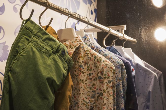 Clothes rack of floral dress shirts and pants in fashion store