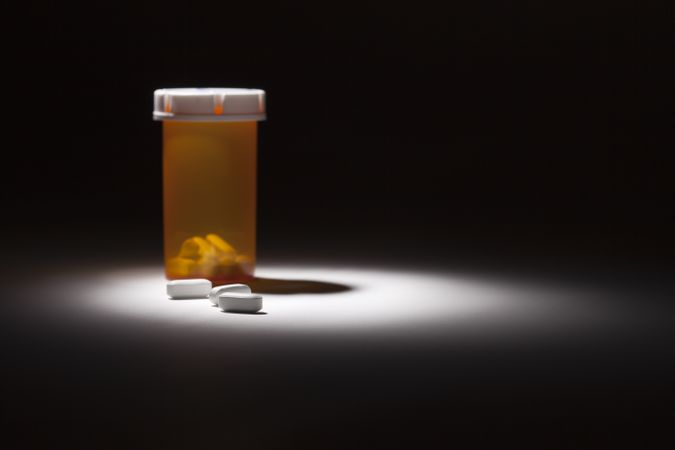 Medicine Bottle and Pills Under Spot Light