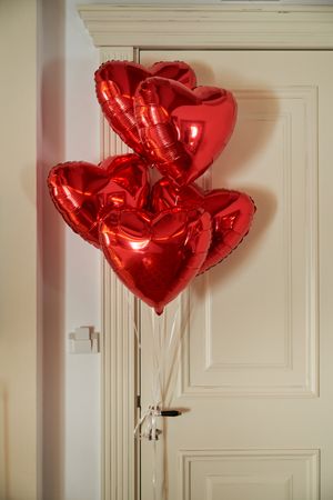 Red heart shaped balloons tied on door knob
