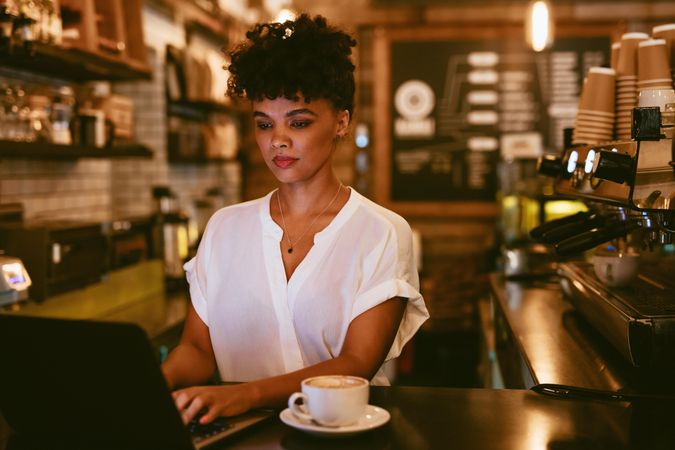 Young woman using laptop at coffee shop