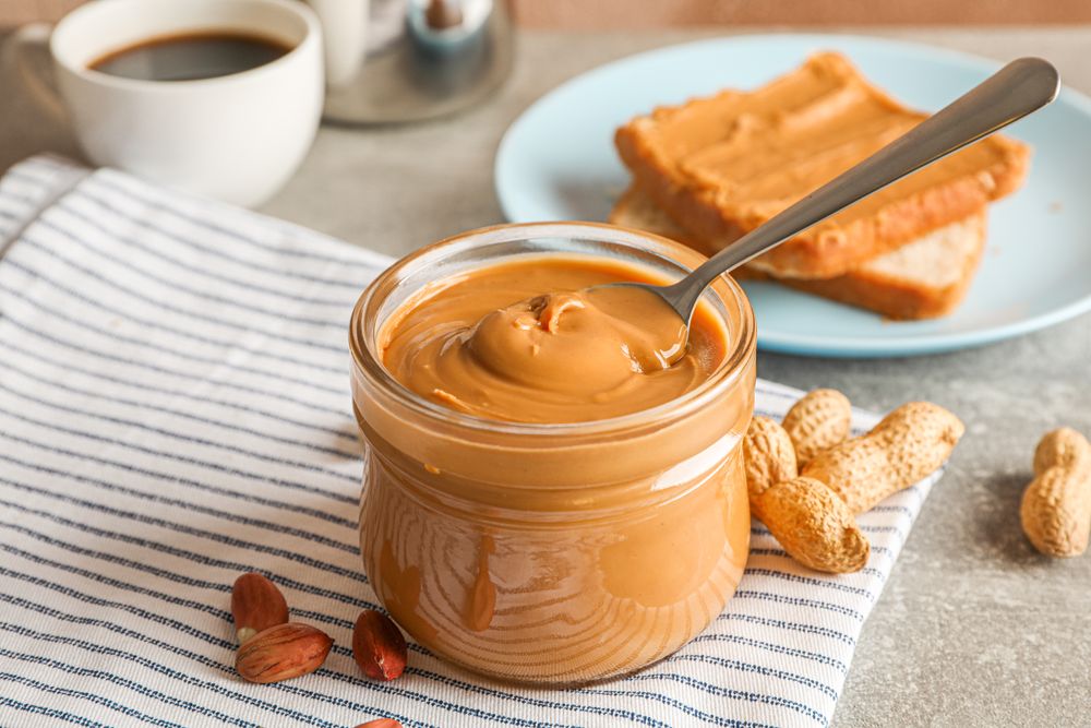 Yummy peanut butter breakfast on grey background, space for text and closeup
