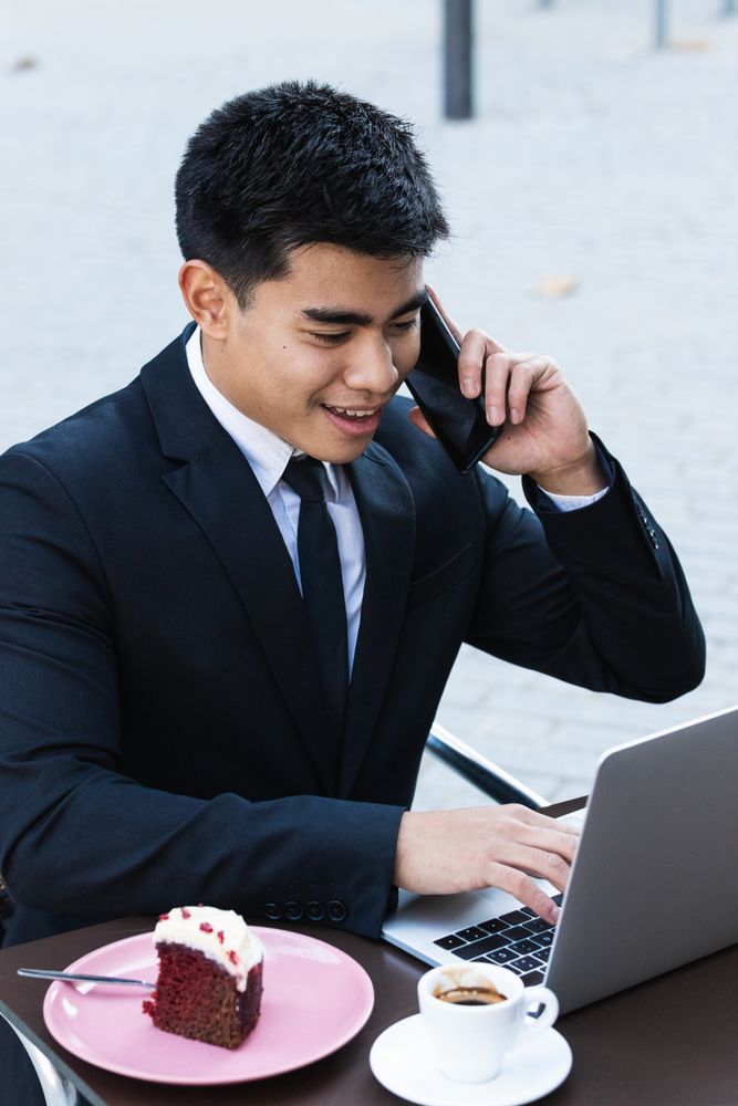 Cheerful businessman working in cafe