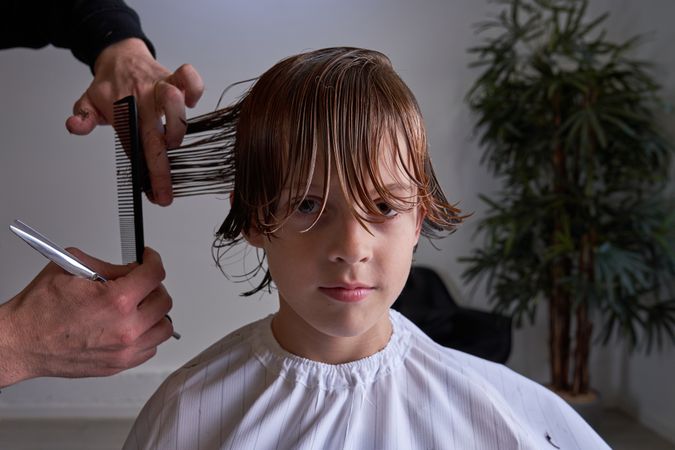 Boy cutting his hair at a hairdresser's
