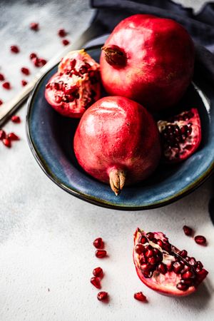 Pomegranates in blue bowl with navy napkin, copy space
