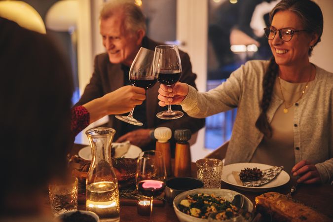 Family enjoying Christmas dinner at home toasting with wine