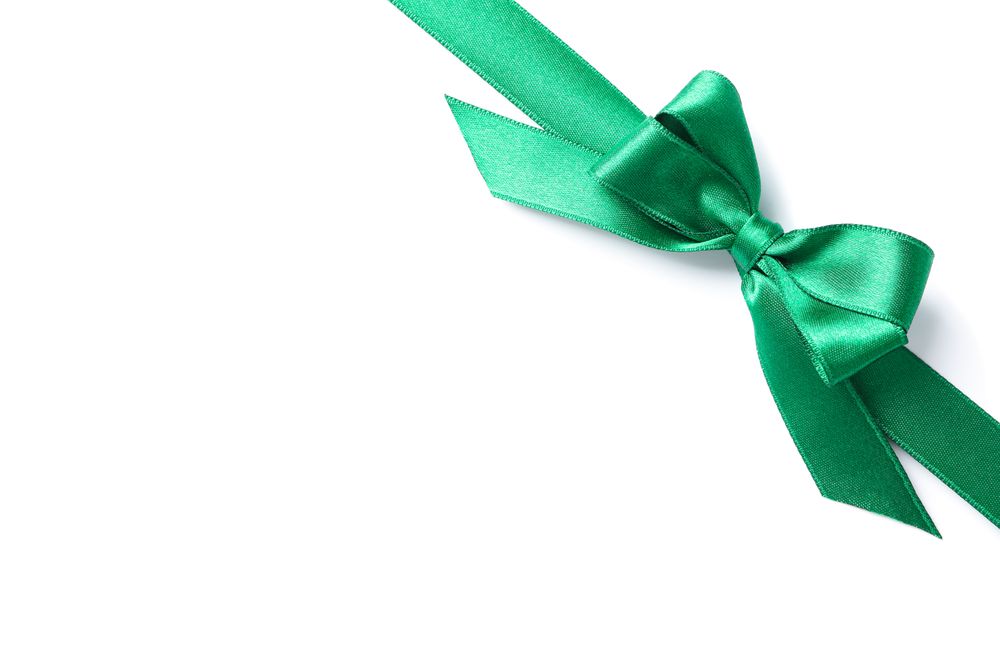 Green ribbon with bow isolated on plain background. Gift concept