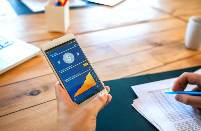 Unrecognizable businessman holding mobile with bitcoins information