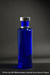 Blue perfume bottle in grey studio with space for text beXzJG