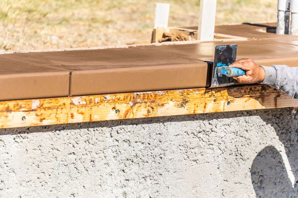 Construction Worker Using Stainless Steel Edger On Wet Cement Forming Coping Around New Pool
