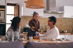 Content parents interacting with little girl in kitchen