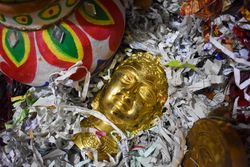 Gold buddha figurine on strips of paper
