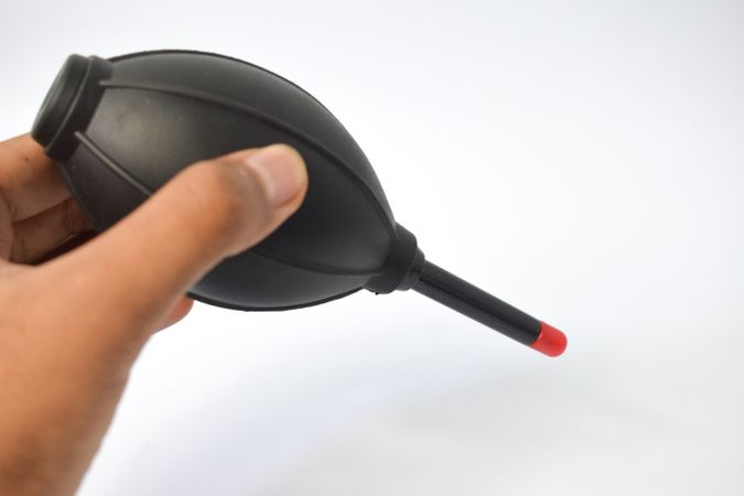 Hand holding dust remover for lenses