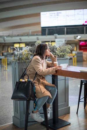 Female sitting and using smartphone at airport