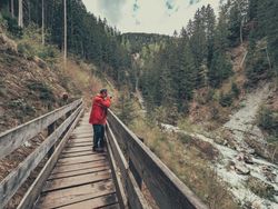 Man taking photo while walking on footpath
