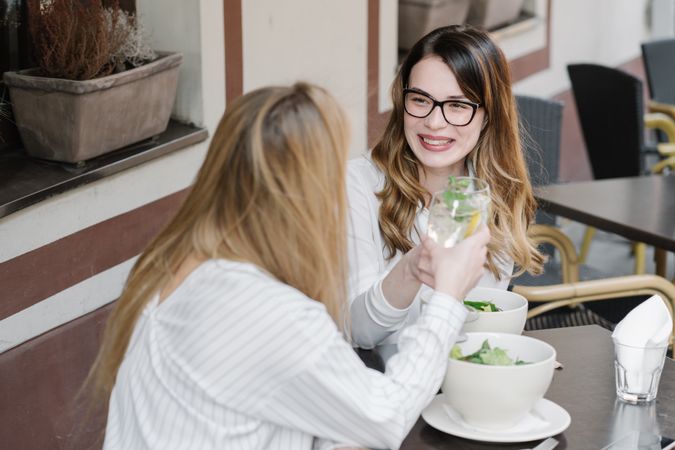 Cheerful women drinking cocktails in bar