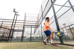 Young man playing paddle tennis. low angle