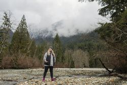 Woman in the mountains standing near a stream