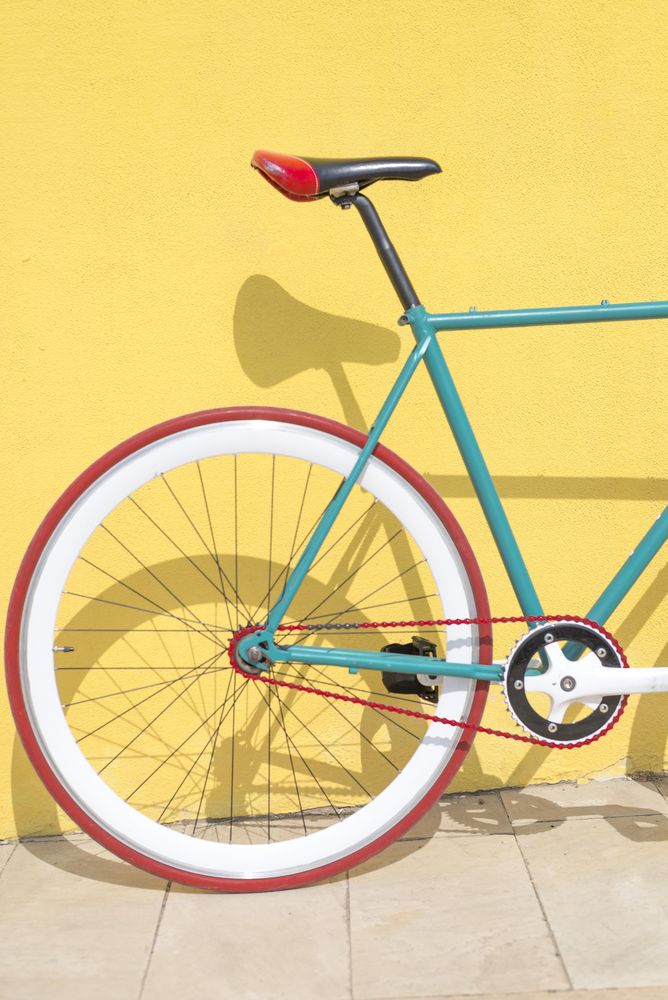 Bike outside on bright yellow wall, vertical