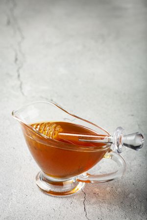 Honey in glass bowl on the table.