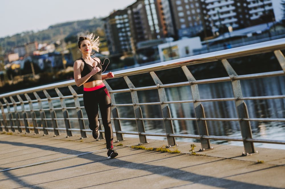 Woman running on embankment near water