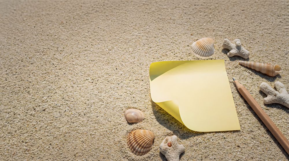 Yellow blank paper note on the beach sand