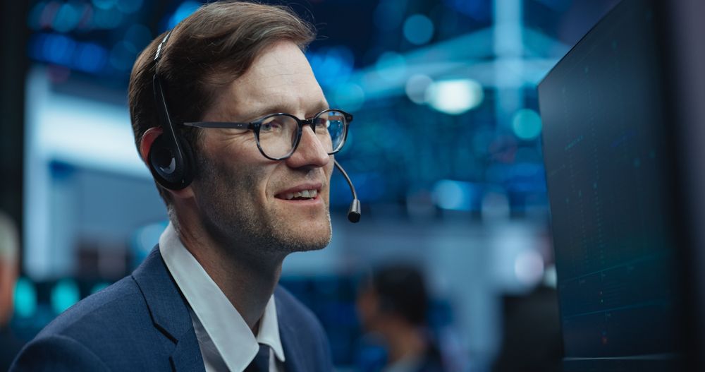 Adult Man Wearing Glasses and Headphones, Researching Investment Possibilities for International Business Corporations