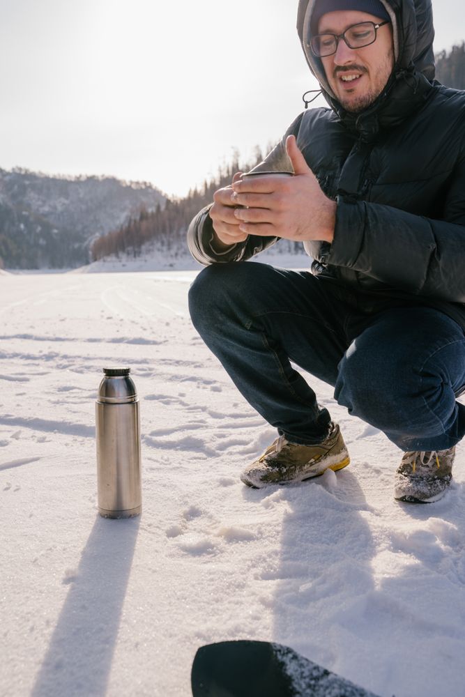 Traveler with enamel mug of tea on winter day