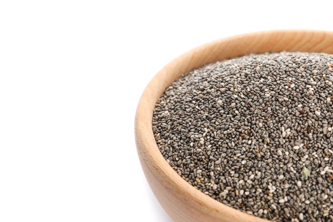 Chia seeds in wooden bowl isolated on neutral background