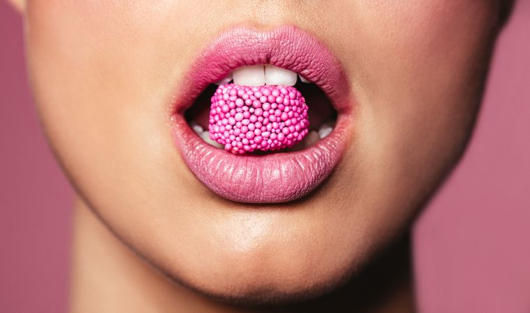 Beautiful pink lips with a piece of sweet candy