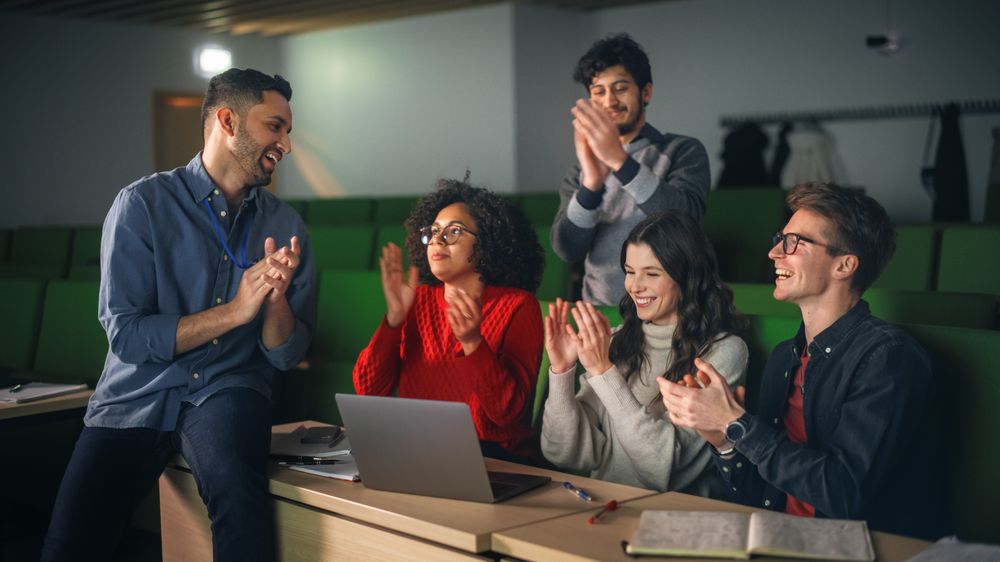 Diverse Students Having a Conversation with a Teacher in University Classroom