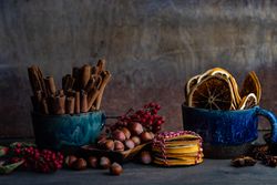 Side view of blue mug with dried orange slices with anise star, cinnamon and holly