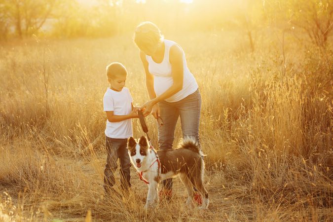 Female and male child walking in nature with dog