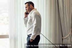 Businessman making call on landline from hotel room bDyNJ0
