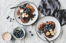 Breakfast banana pancakes with blueberry, honey and coffee, top view, horizontal