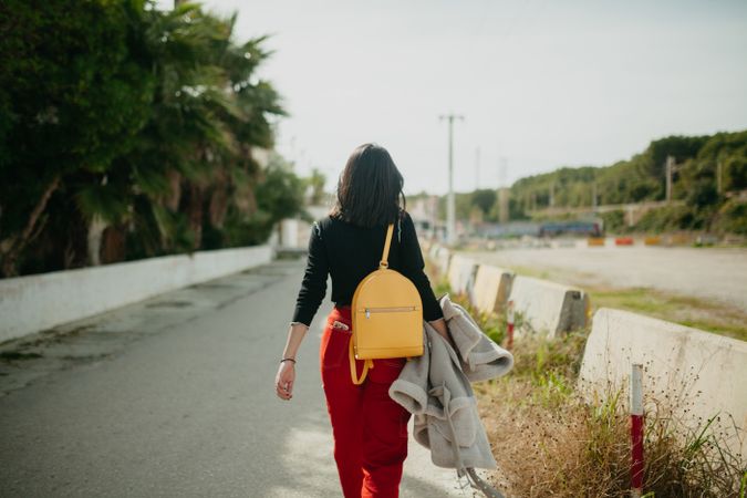 Stylish woman walking on beach parking