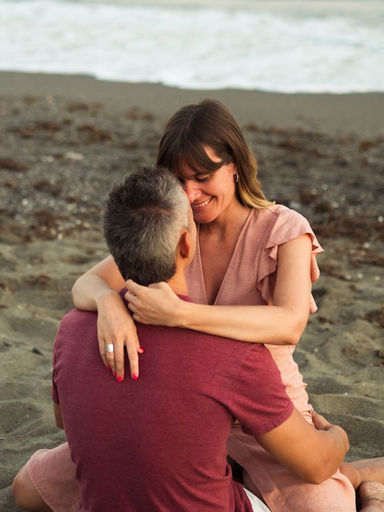 Delighted couple sitting on beach