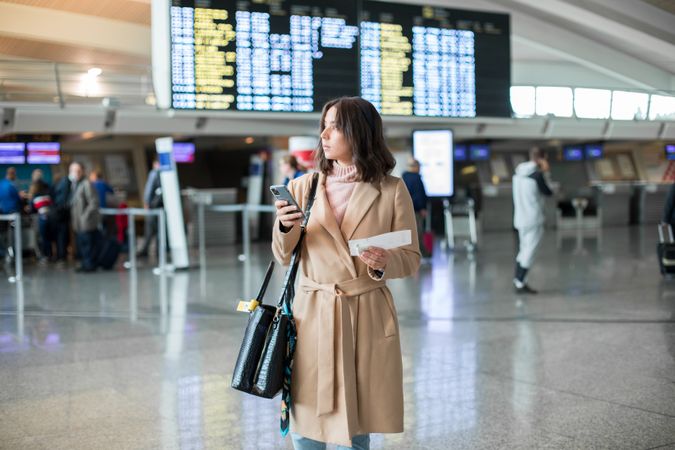 Woman using smartphone at airport