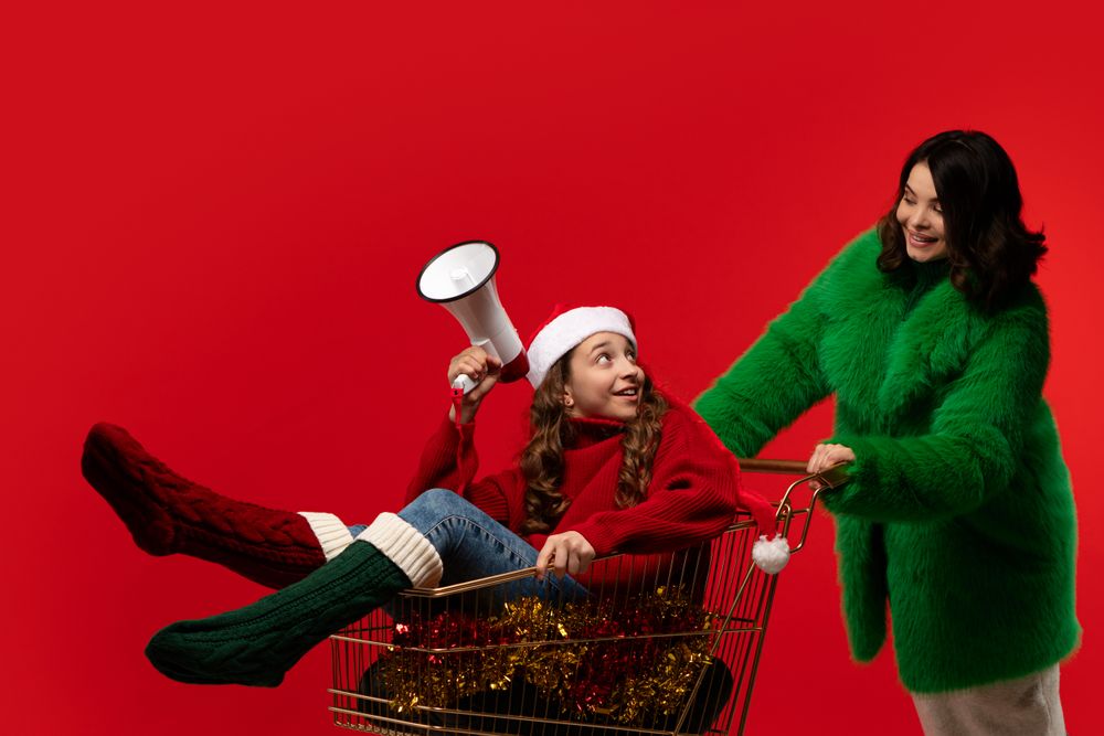 Surprised girl with megaphone in cart, woman in green coat