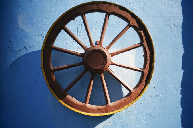 Old iron wheel on blue wall