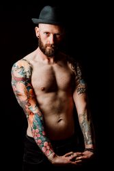 Young shirtless bearded guy with tattoos