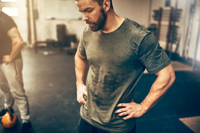 Sweaty man looking down mid-workout