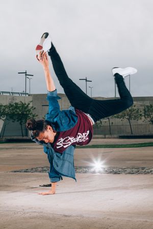 Skillful break dancer performing handstand while moving