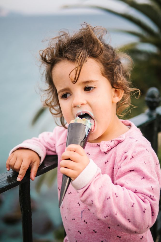 Adorable serious toddler girl with ice-cream