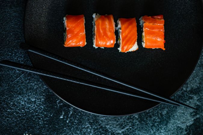 Top view of salmon sushi rolls served on stone slate