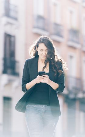 Young female walking with smartphone