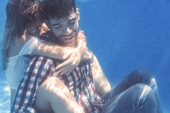 Dressed Couple embracing underwater